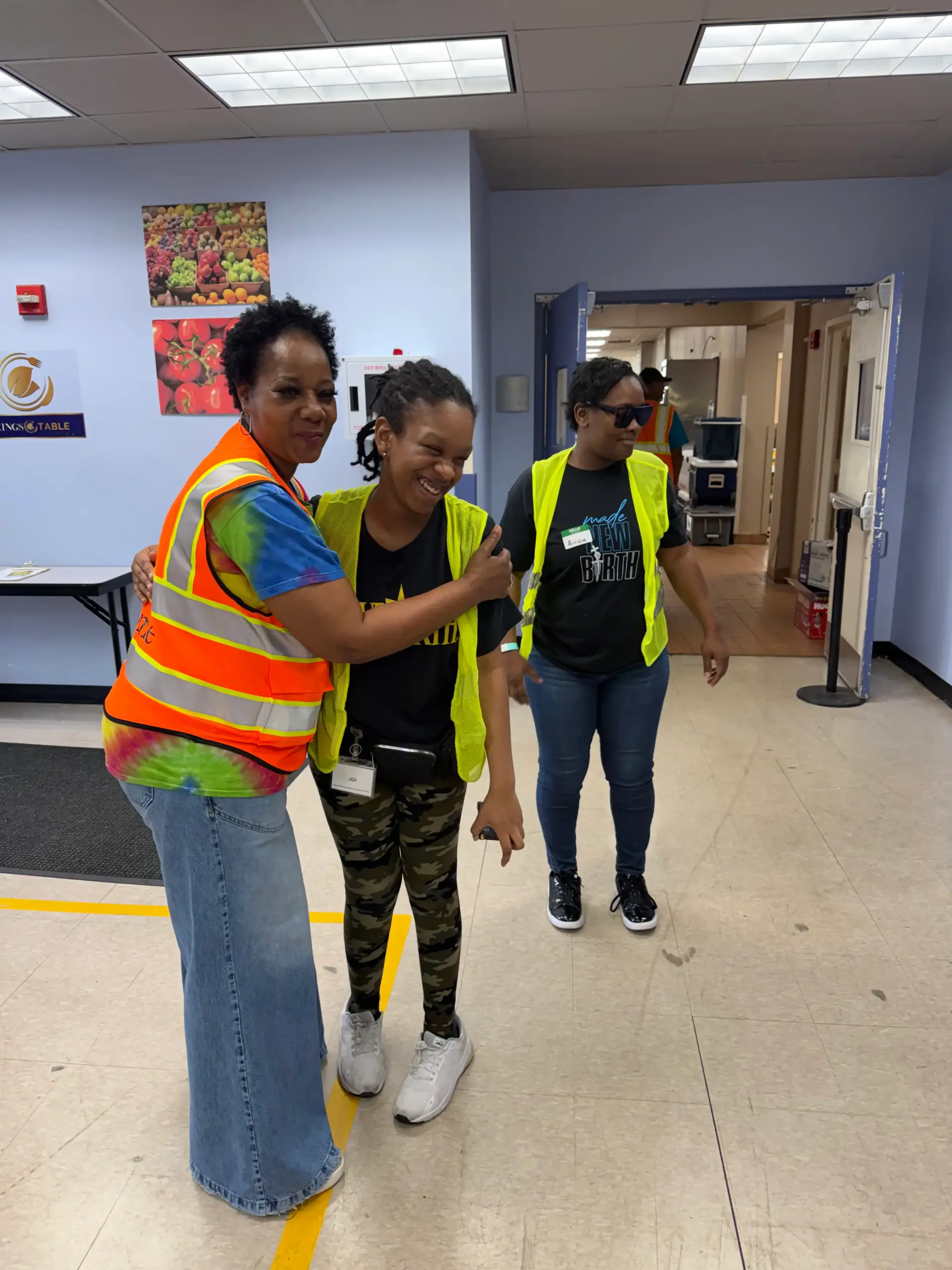 Volunteers in safety vests smiling together at a community service event
